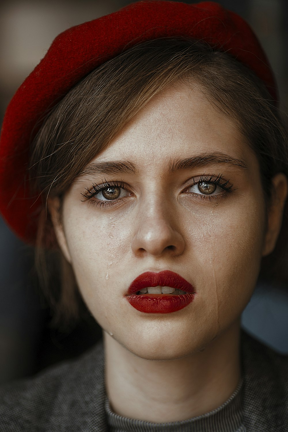 Mujer con camisa gris y sombrero rojo