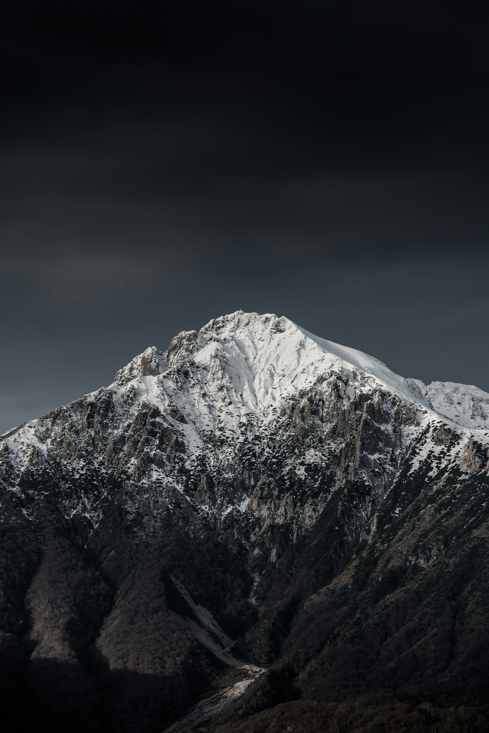 montaña cubierta de nieve bajo el cielo nublado