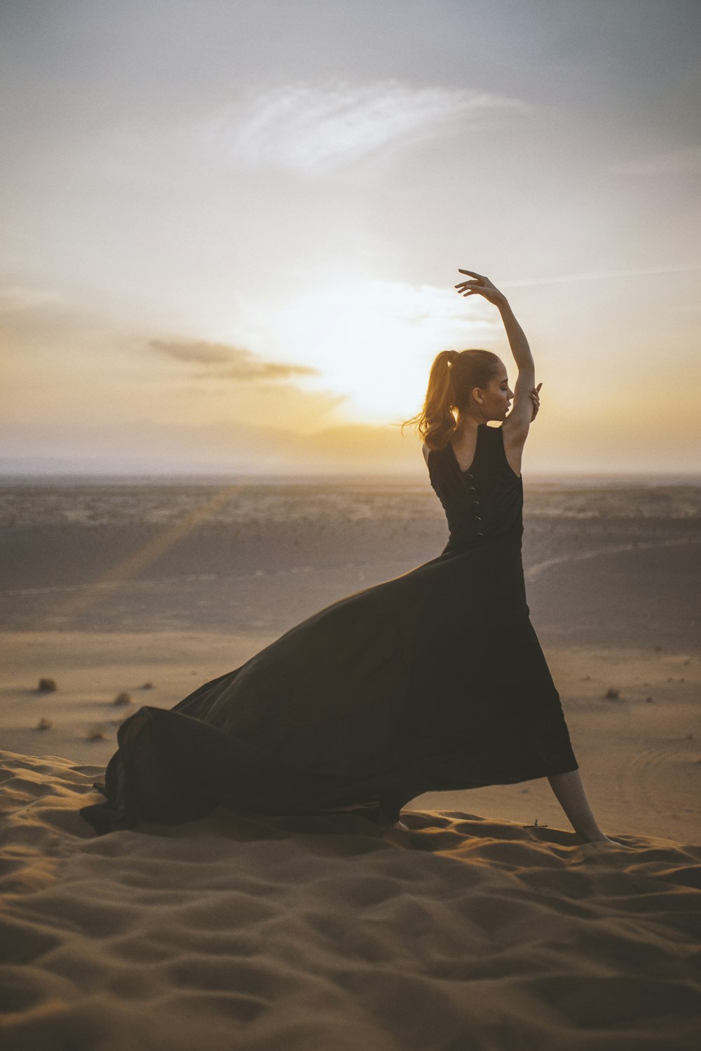 woman wearing black sleeveless dress near body of water