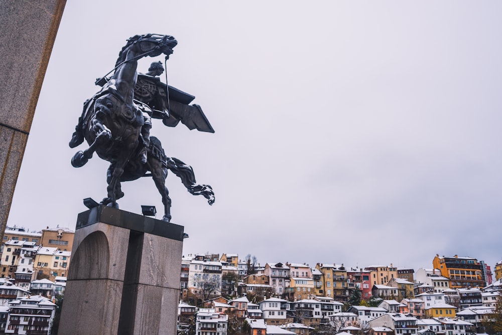statue of man riding horse beside building