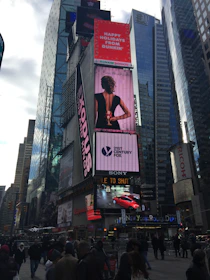 Bright and colorful outdoor signage displayed on a busy street corner.