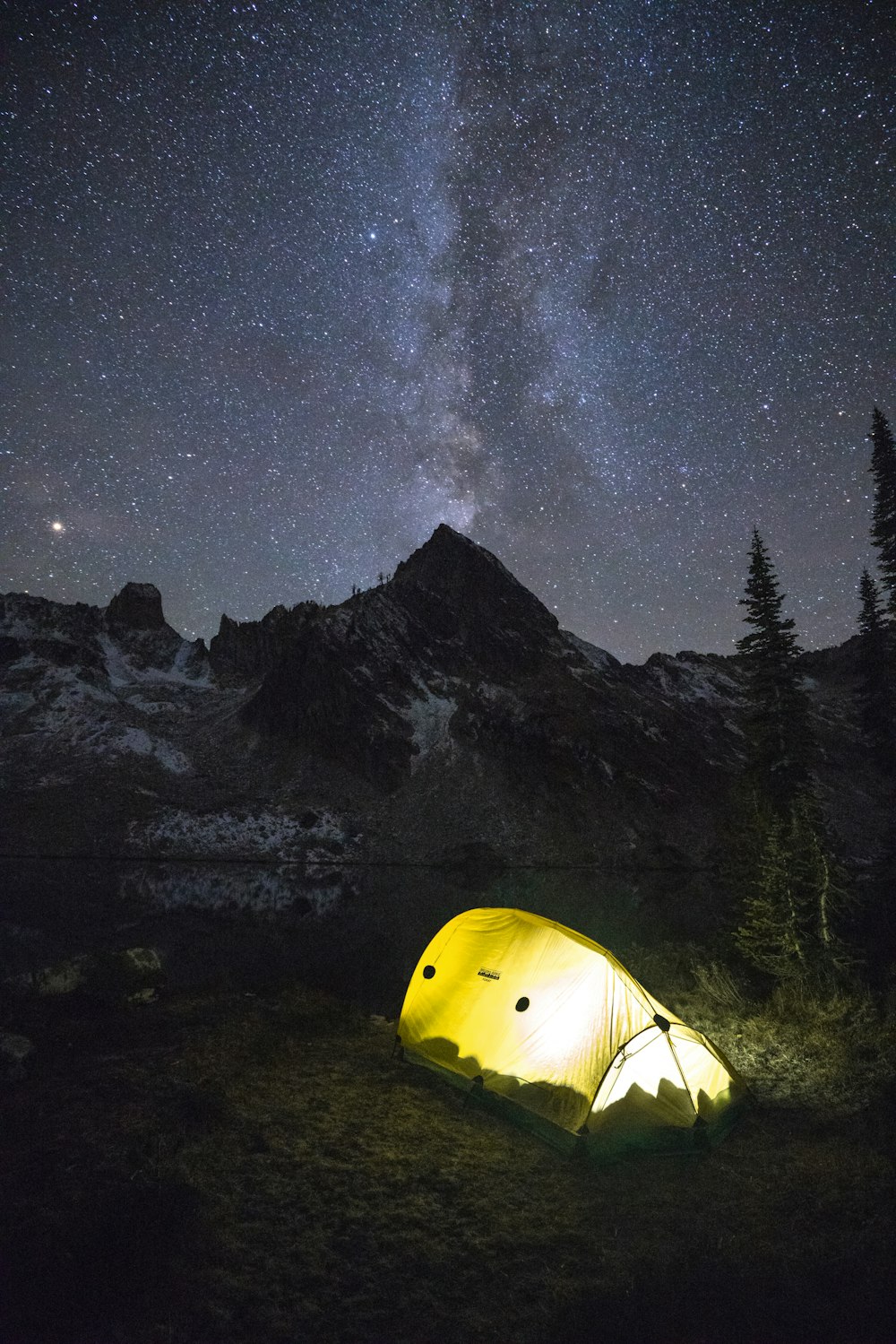 lighted lamp in yellow dome tent under milky way