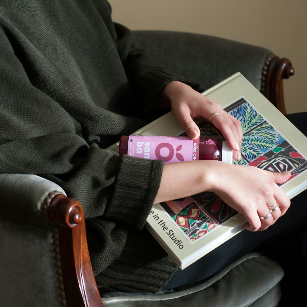 personne tenant une bouteille étiquetée en violet