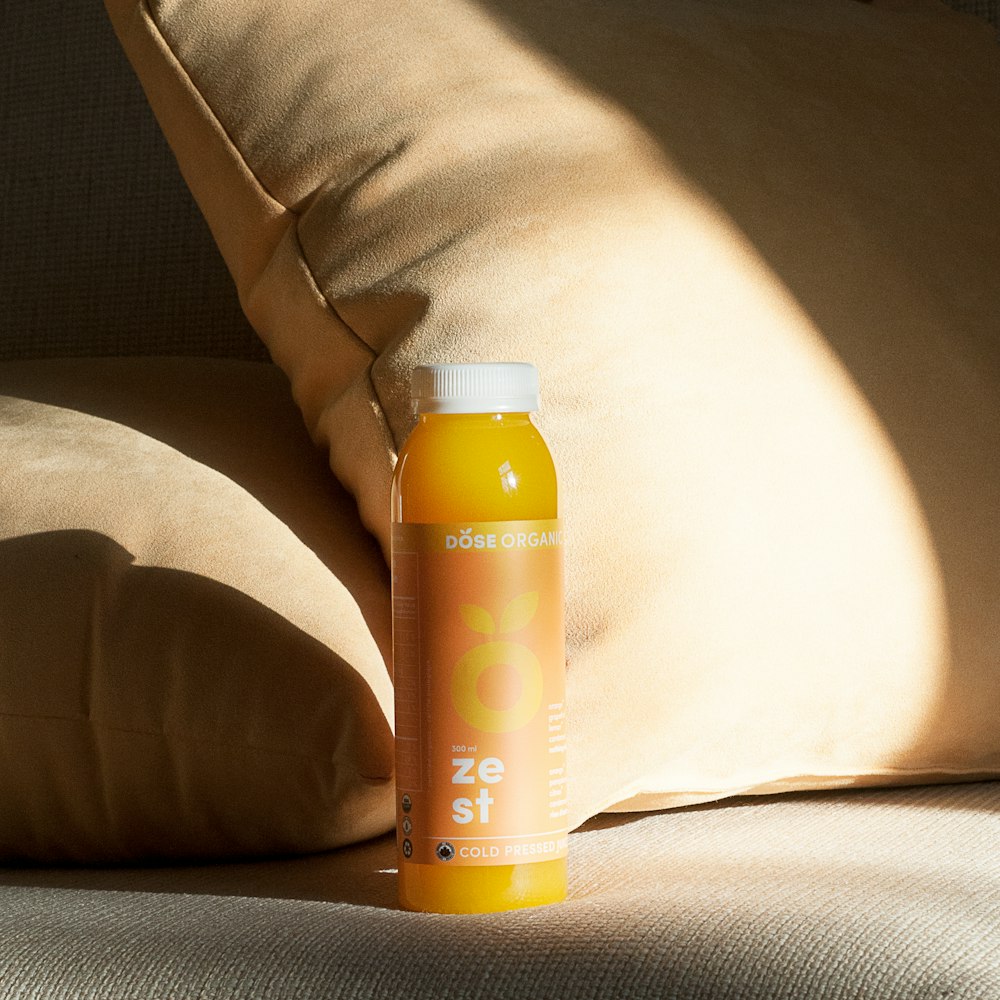 orange plastic bottle on gray surface