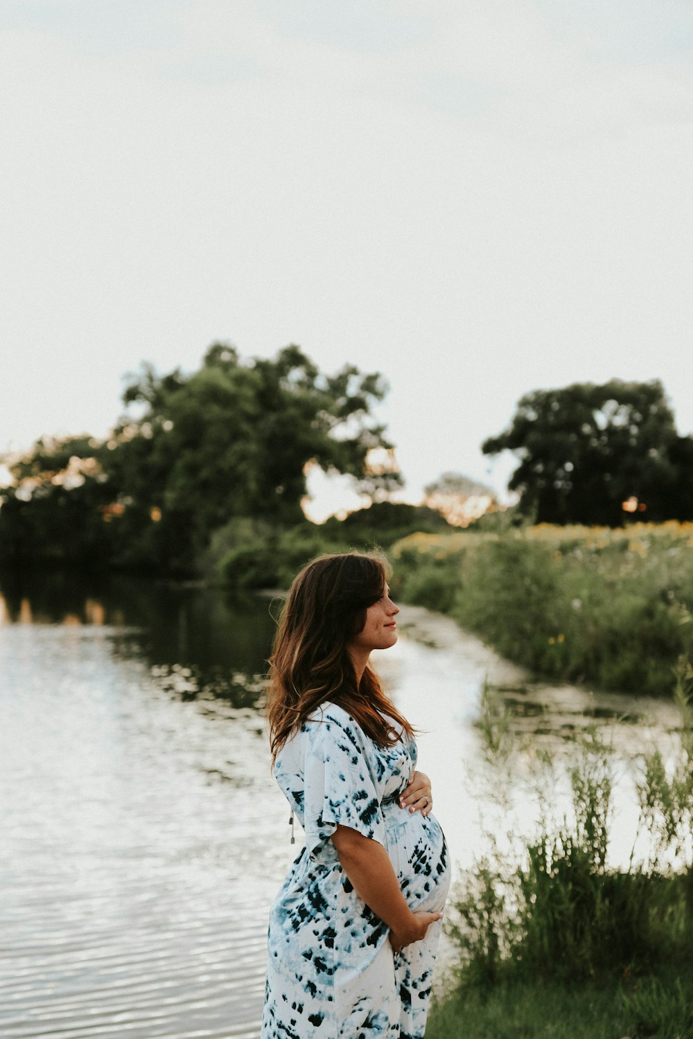 woman in black and white short-sleeved dress standing near body of water