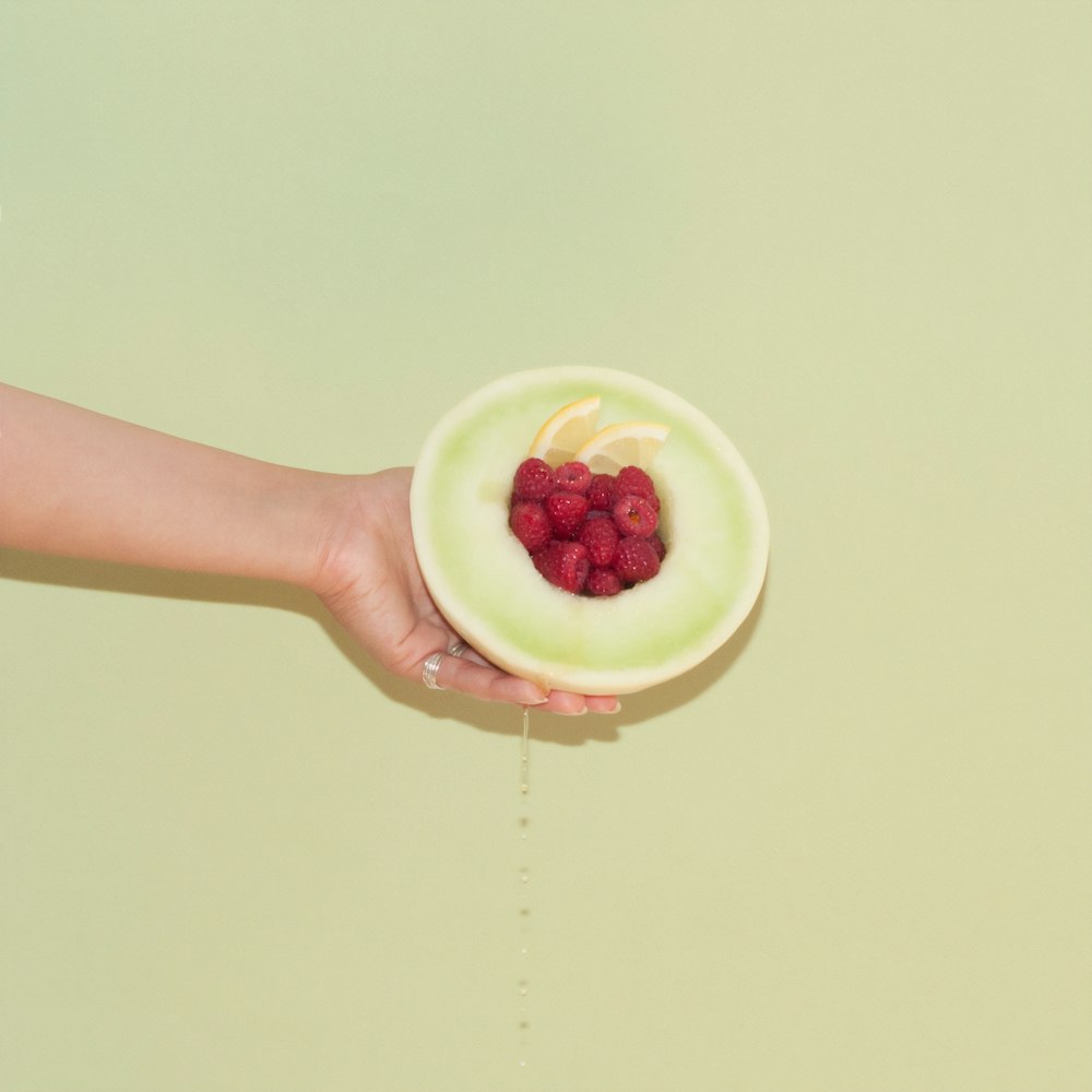 person holding raspberry fruits