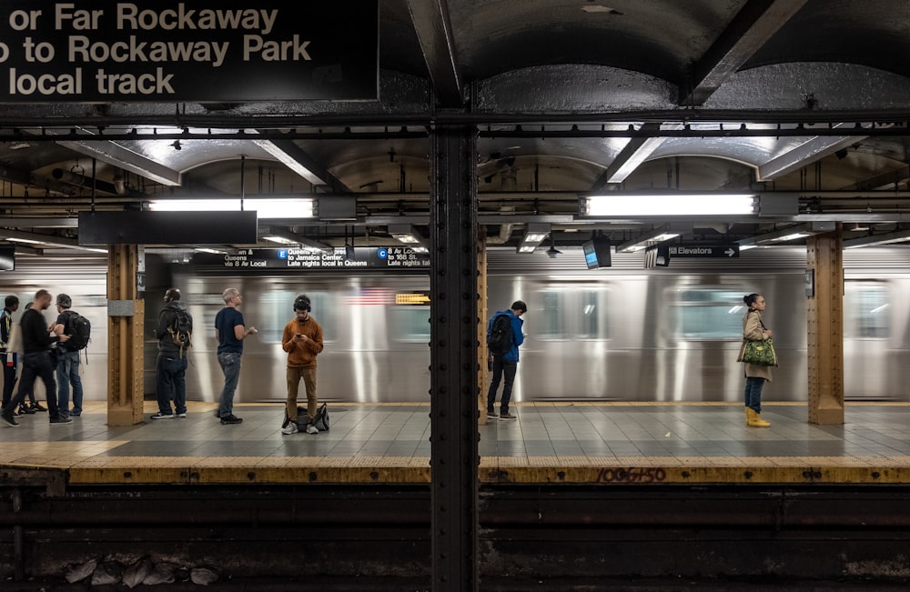 people standing in front of train rail