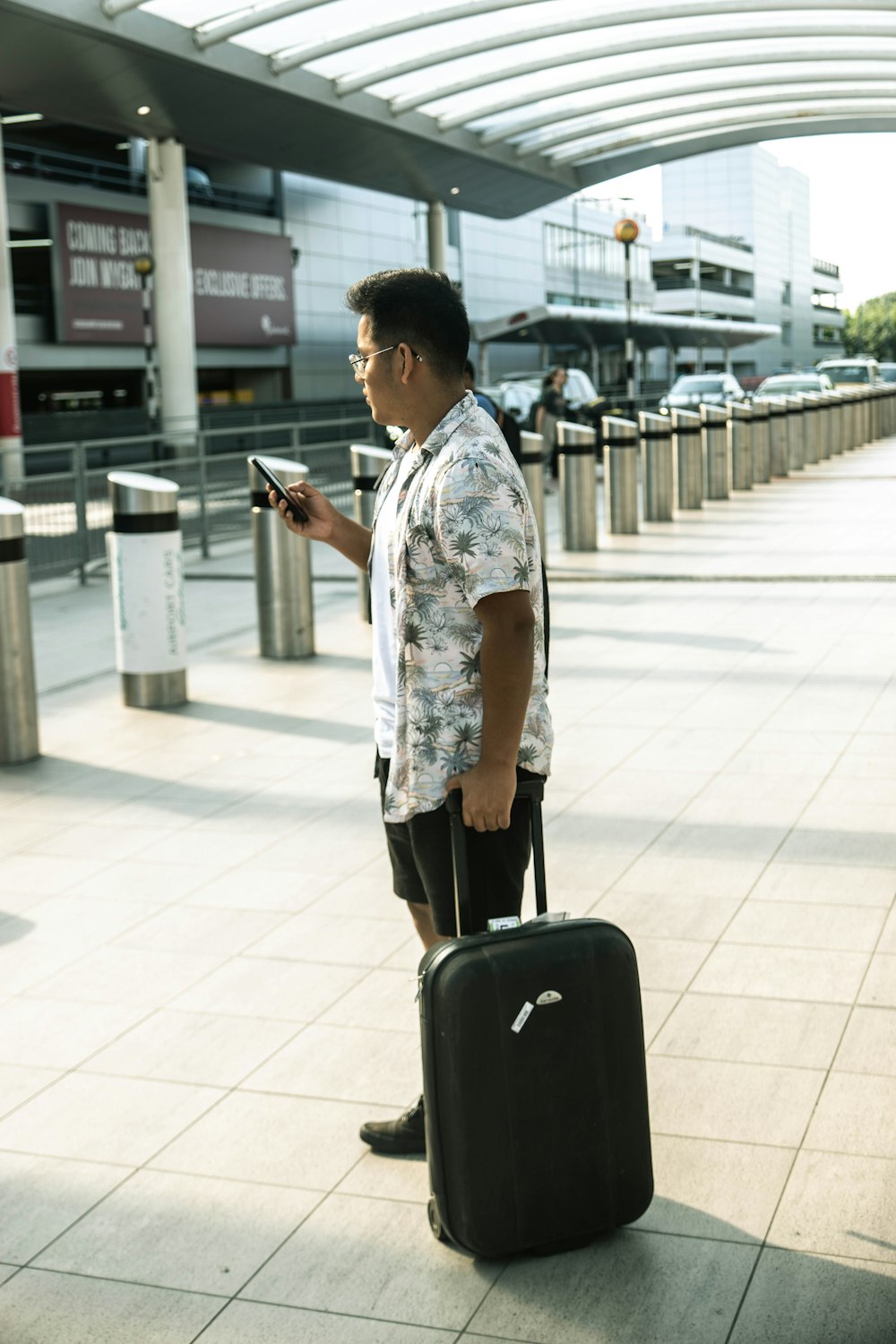 man standing holding luggage during daytime