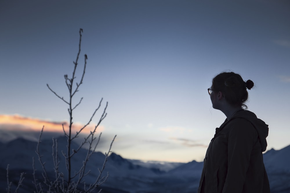 woman in gray jacket looking at the mountain