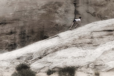 A person climbing a steep mountain trail with determination.