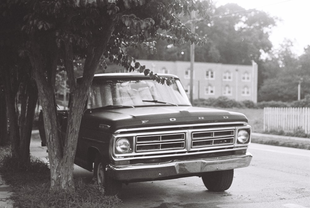 grayscale photography of vehicle near trees