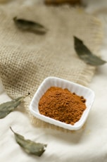 a small white bowl filled with brown powder