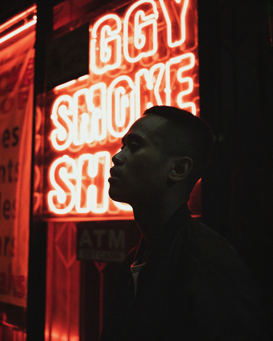 man standing beside neon light