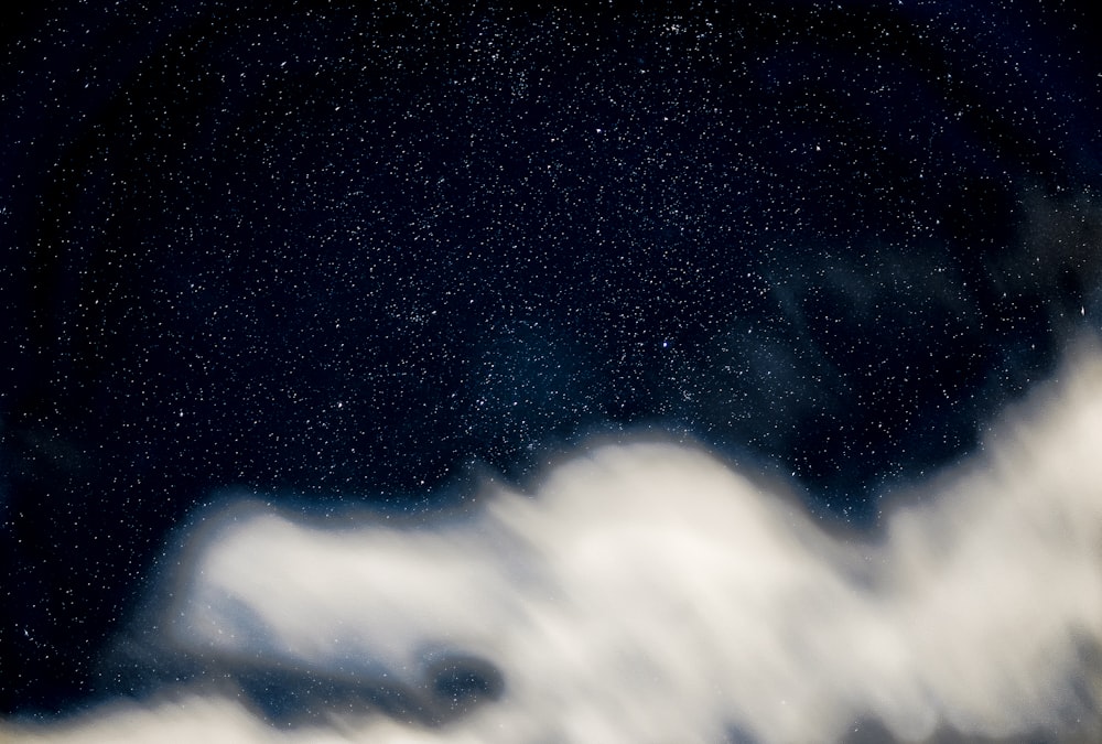 a black and white photo of some clouds and stars