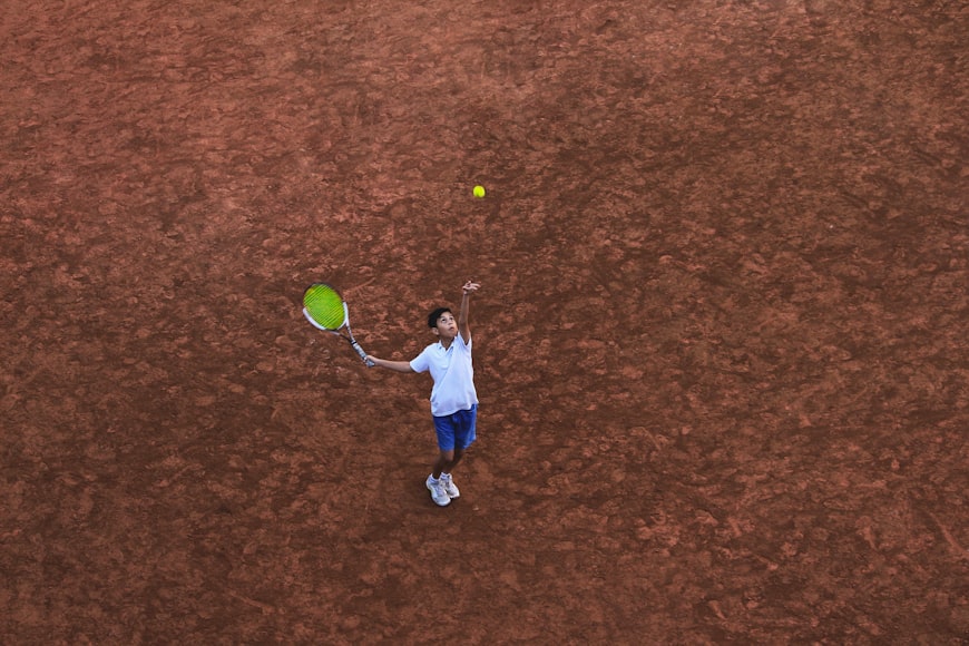 Chłopiec rzuca piłkę tenisową