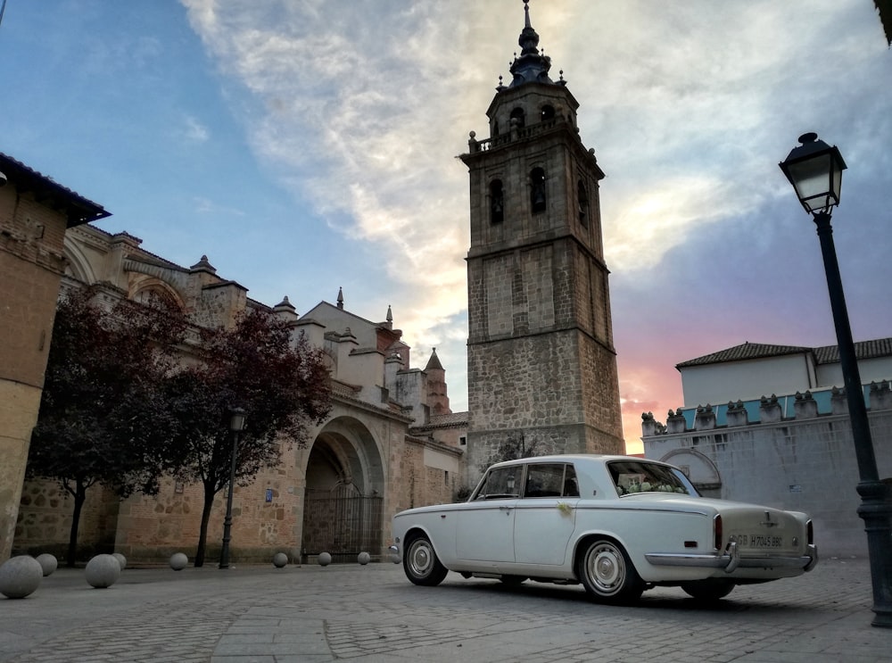 white sedan near brown concrete church