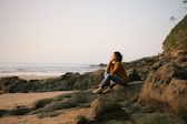 woman sitting near sea during daytime