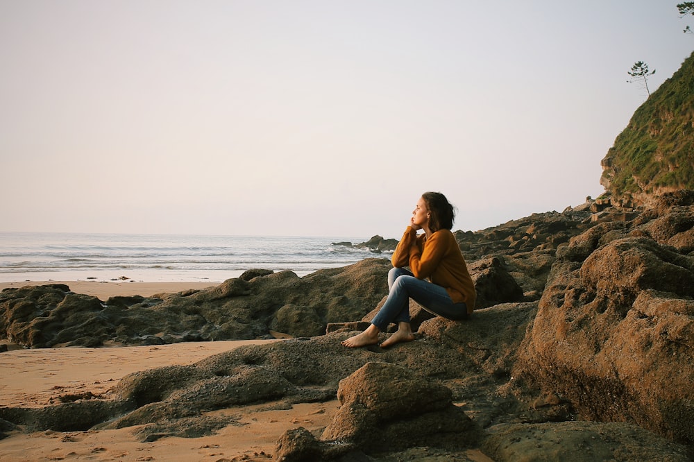 woman sitting near sea during daytime