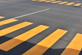 Close-up of vibrant yellow and white parking lot lines highlighting pedestrian walkways.