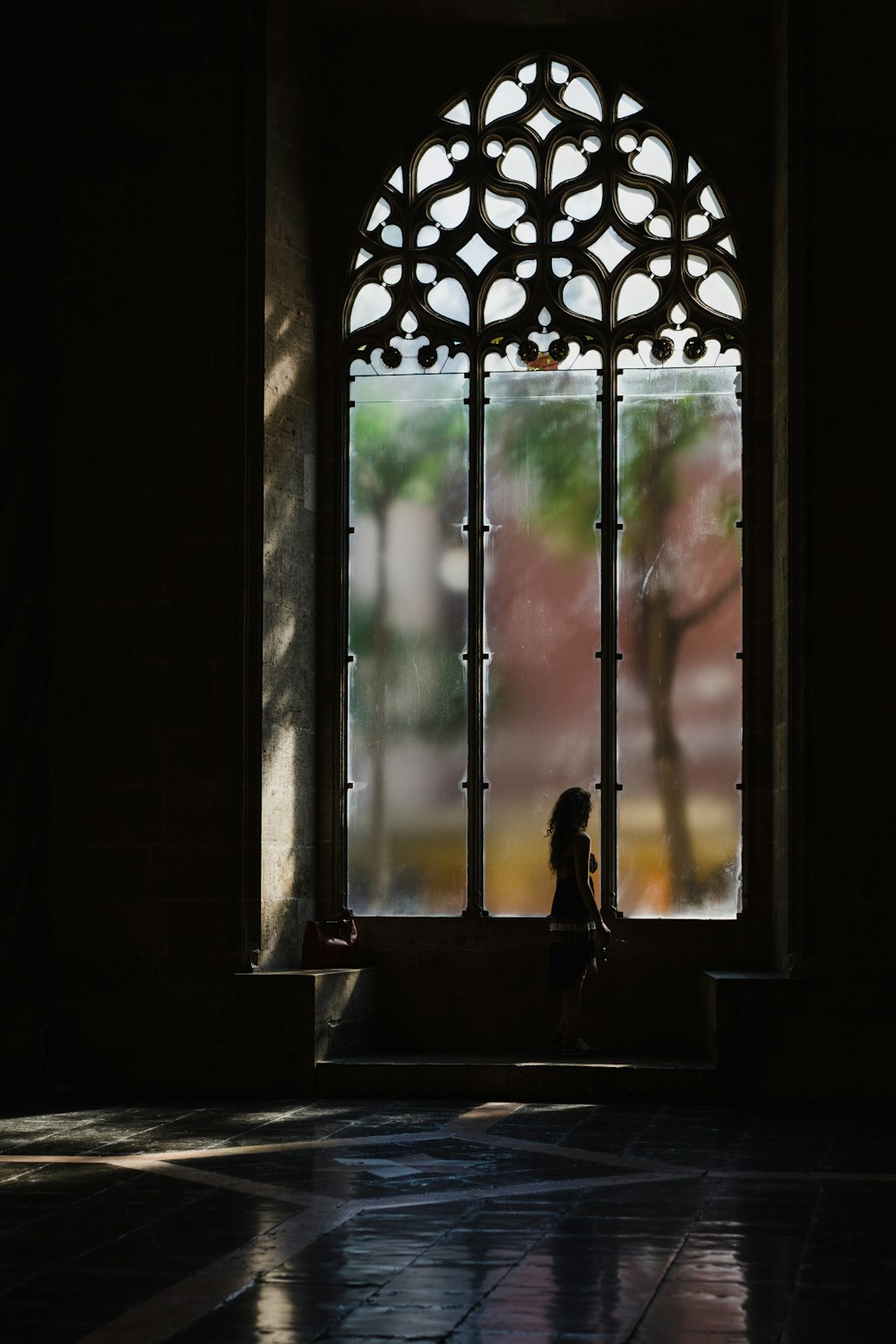 person standing beside framed glass window