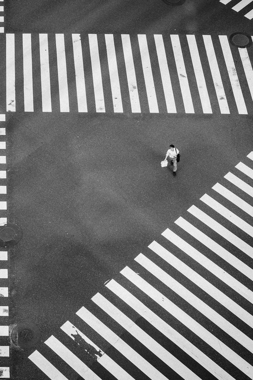 man walking at the center of crisscrossing pedestrian lanes