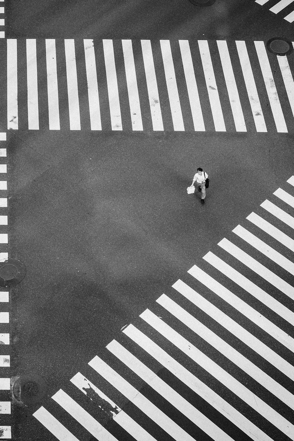 Homem caminhando no centro de faixas de pedestres