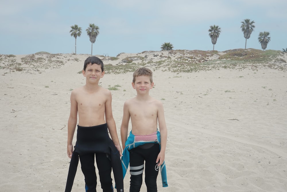 two topless boys at the seashore