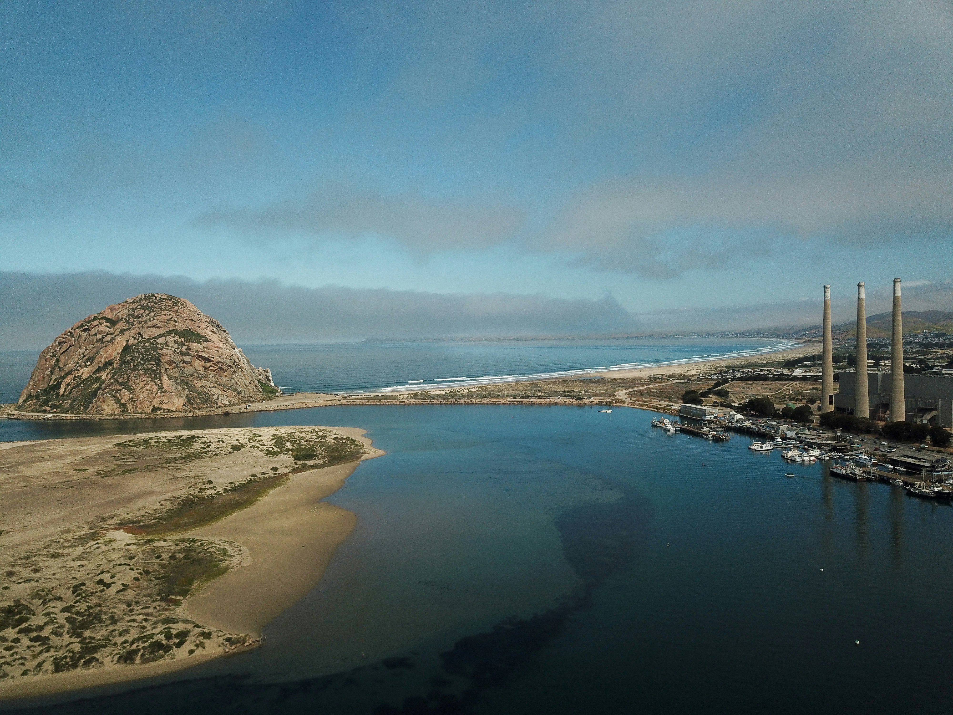 aerial photography of island overlooking hill and plantation under white clouds and daytime