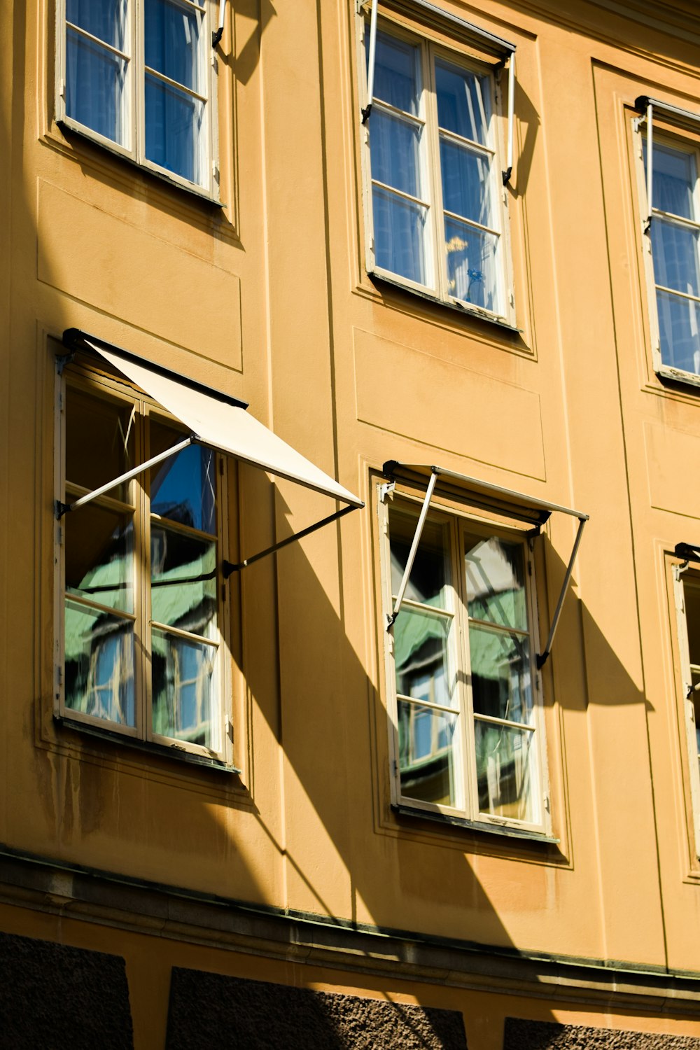 Edificio de hormigón marrón con ventanas abiertas durante el día