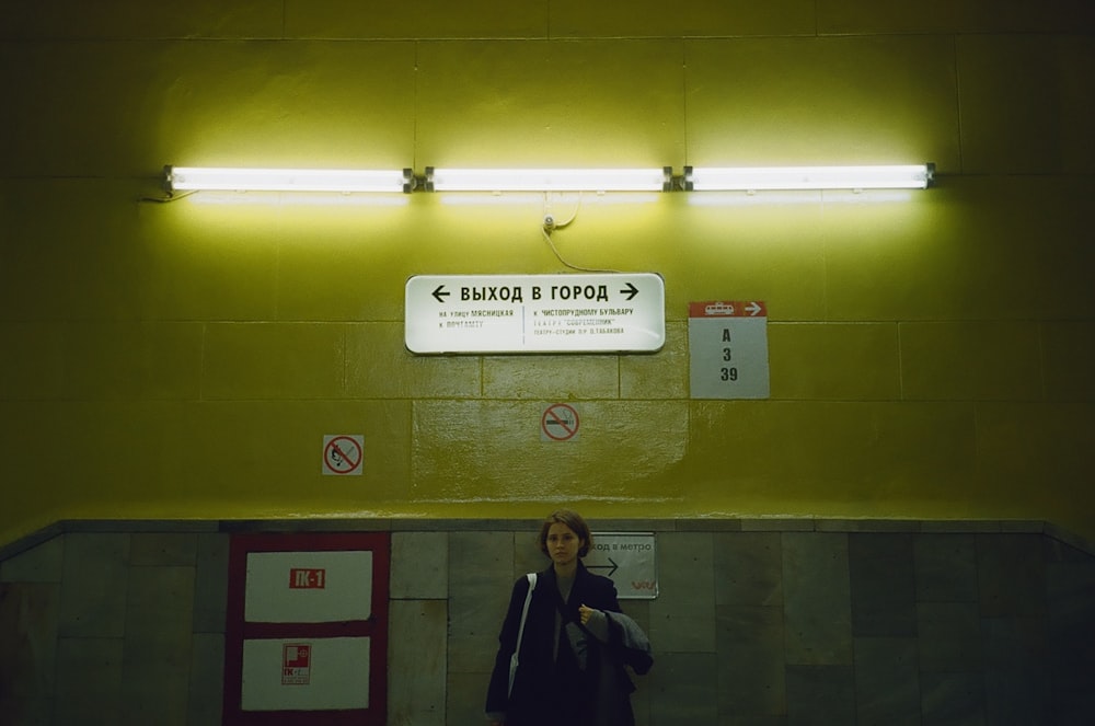 woman standing above lighted fluorescent bulb