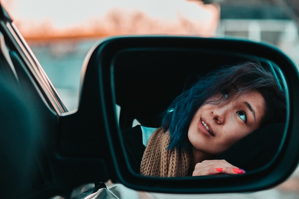 selective focus photo of woman looking on up reflecting on side mirror