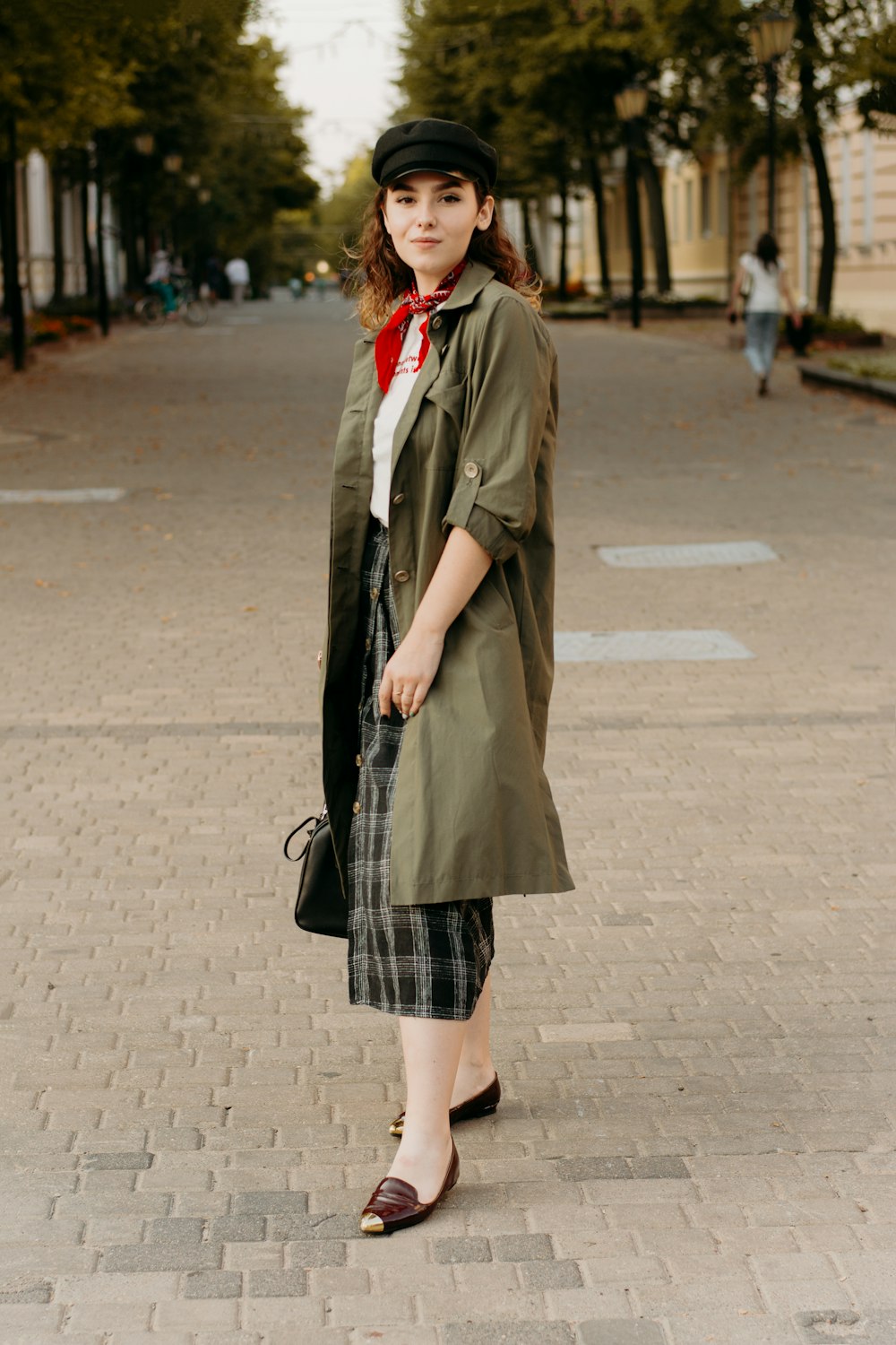 woman in black coat standing on road