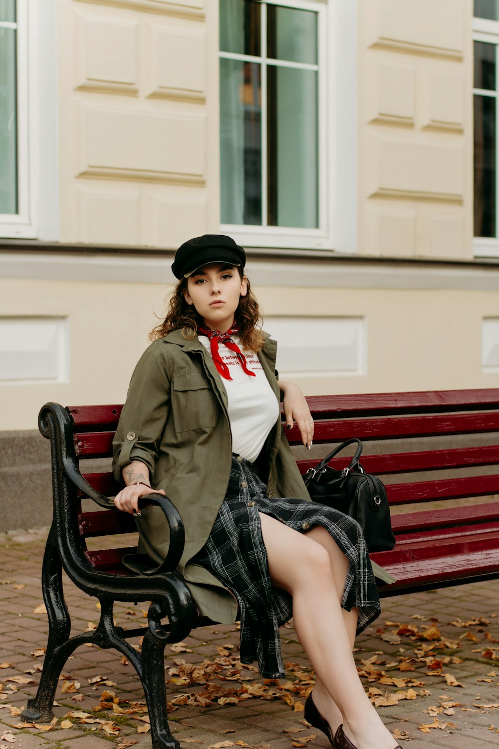 a woman sitting on a bench in front of a building