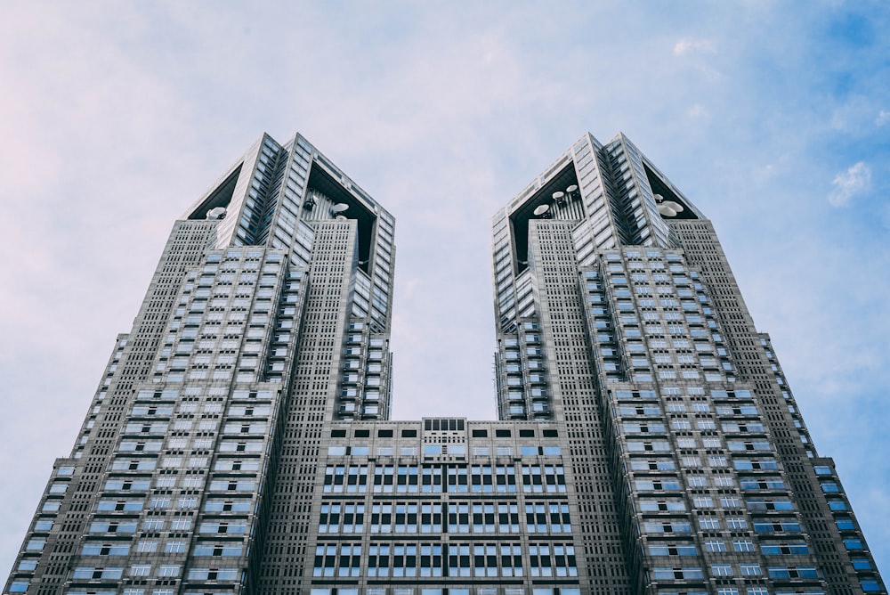 edificio gris de gran altura bajo cielo blanco y azul