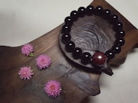 A stylish agarwood bead bracelet resting on a polished wooden surface with warm lighting