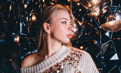 A sparkling sequin sweater catching the light on a mannequin against a neutral background.