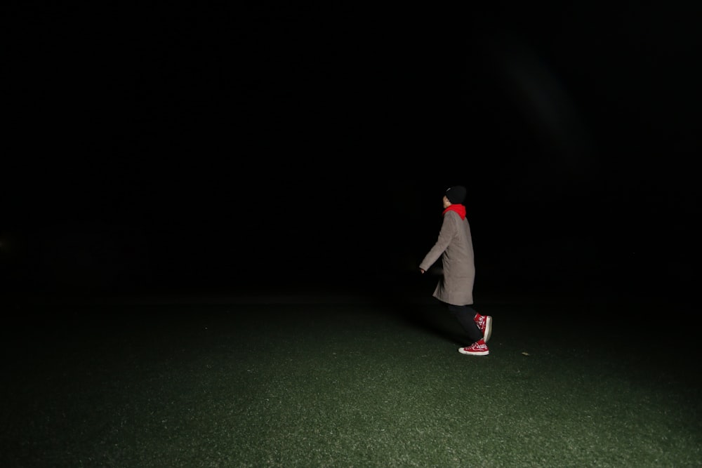 person standing on grass field during nighttime