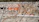 A wall mural features intricate floral and paisley designs with earthy colors like orange and brown. In the foreground, the phrase 'We Love Rishikesh' is painted, with 'Love' styled as a heart symbol. The background is a textured gray wall.
