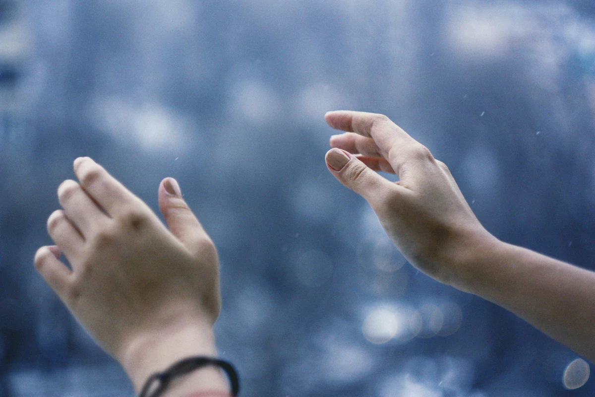 Pale cold hands reaching out in winter light
