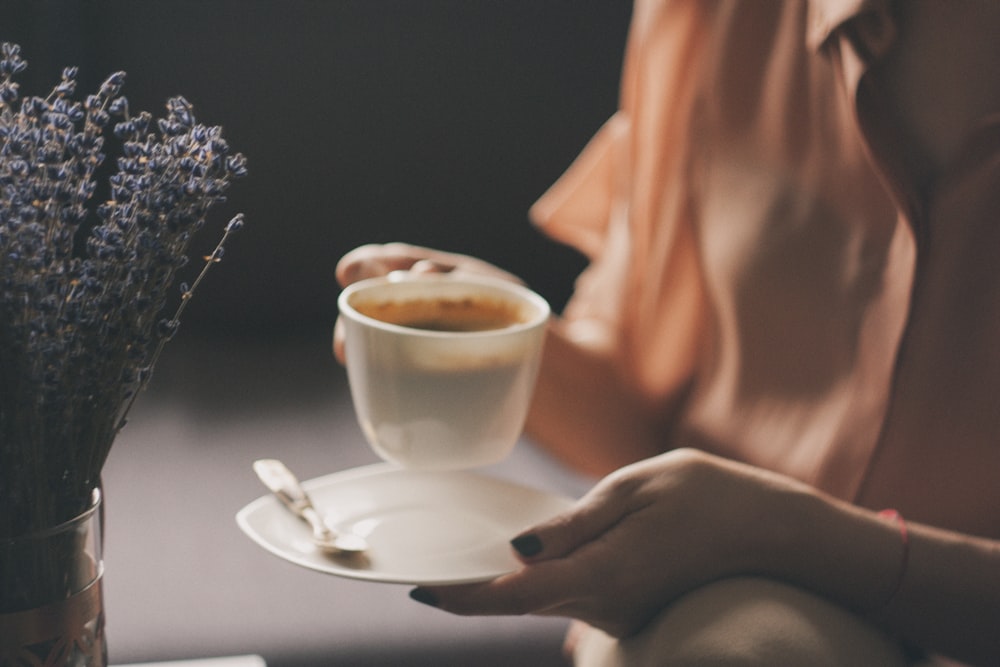 person holding filled coffee cup