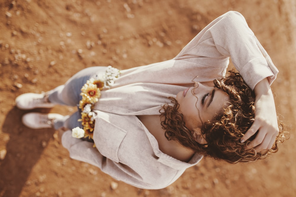 woman wearing beige top standing on brown dirt high-angle photography
