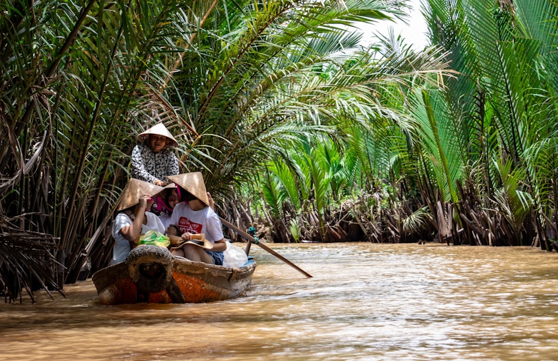 Hanoi or Ho Chi Minh City? group of people riding on canoe in the mekong delta