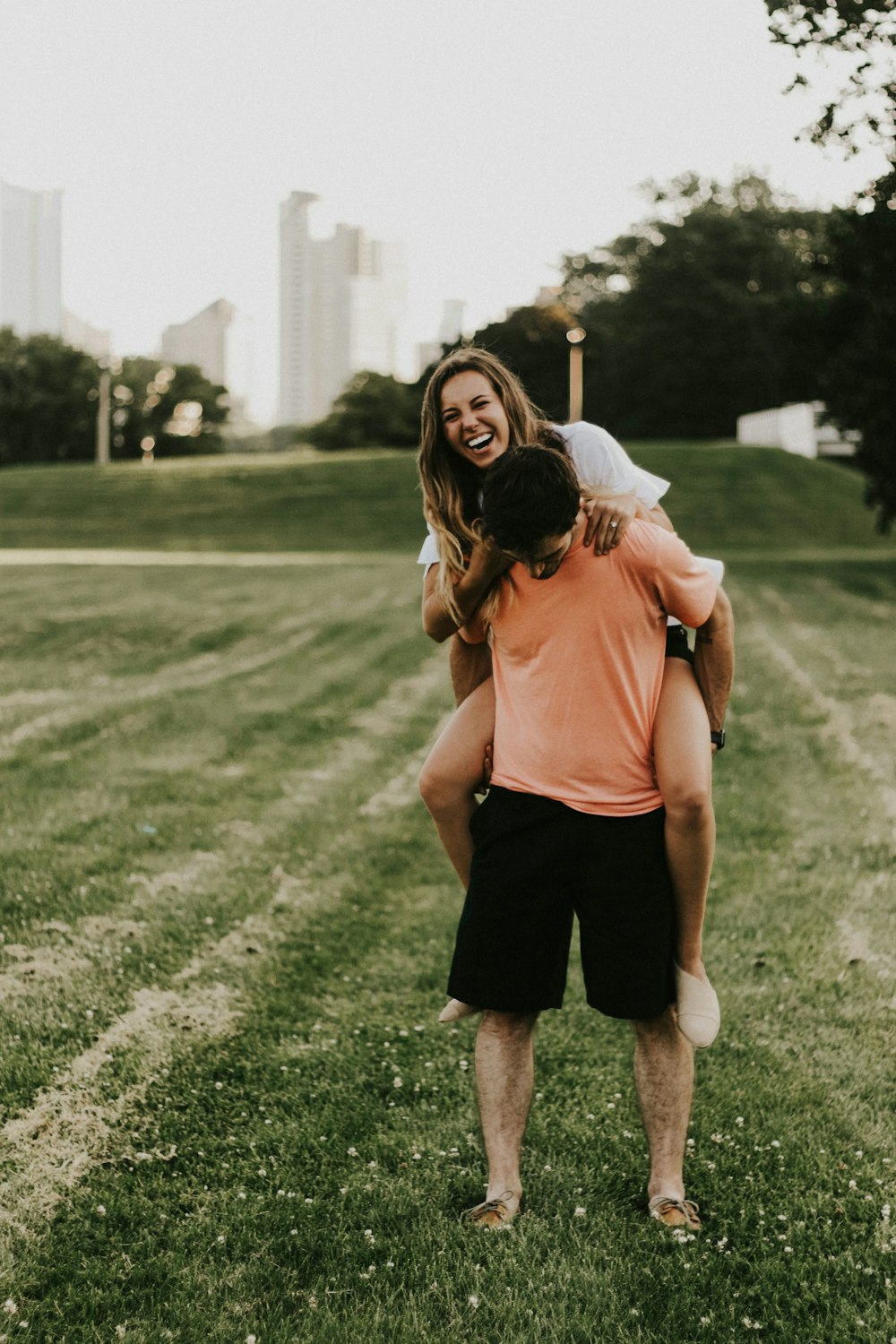 selective focus photography of man carrying woman on grass field