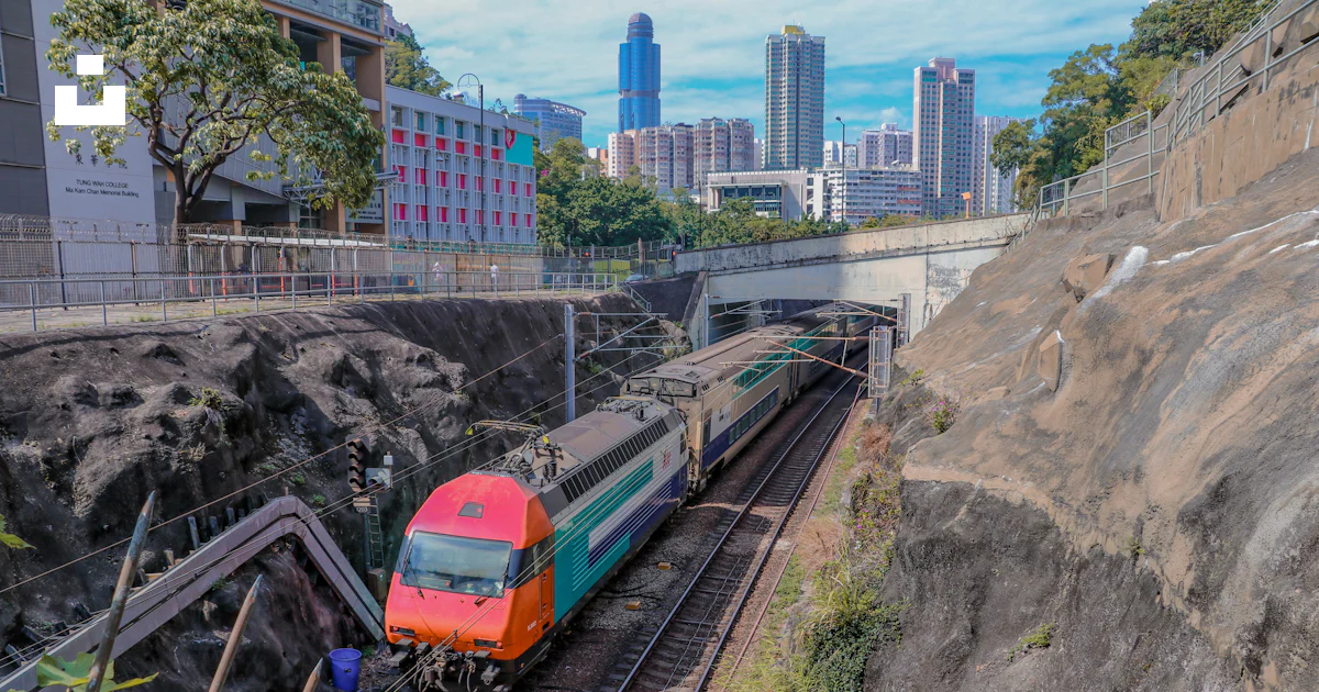 Green and red train near buildings photo – Free Train Image on Unsplash