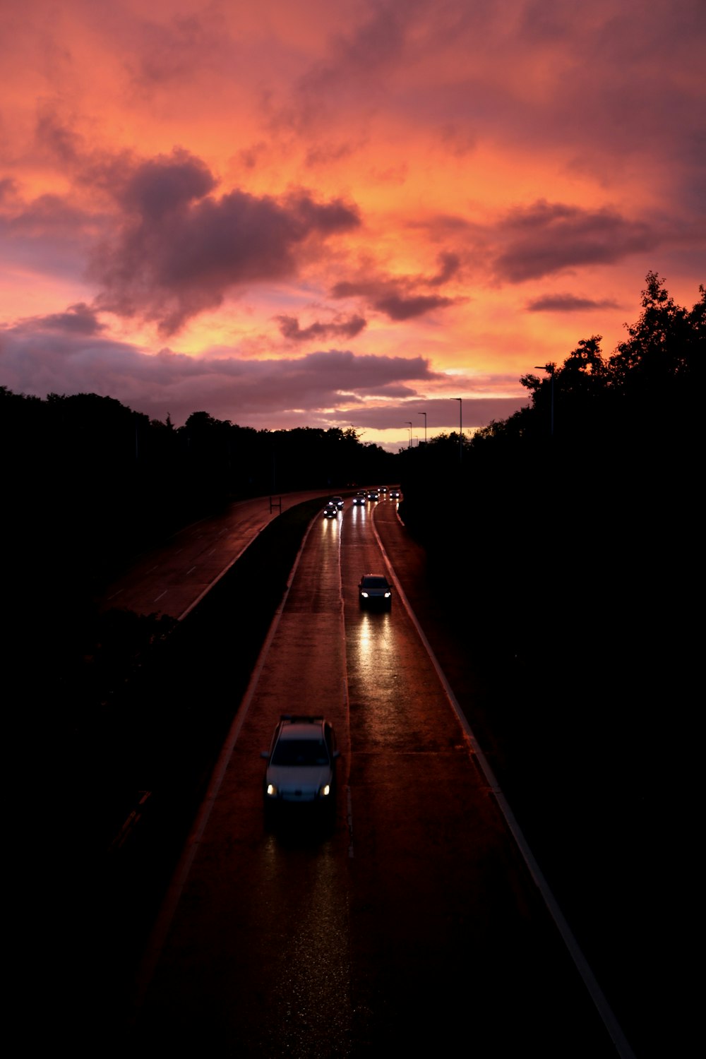 Varios vehículos en la carretera durante la puesta de sol