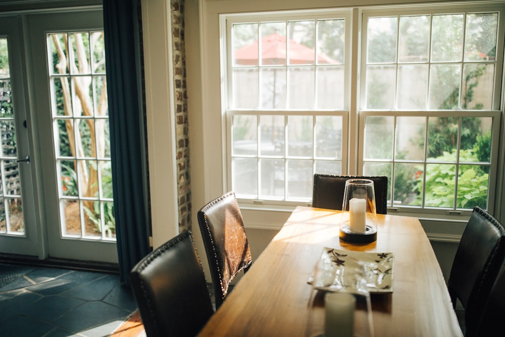 brown wooden dining table and black leather chairs