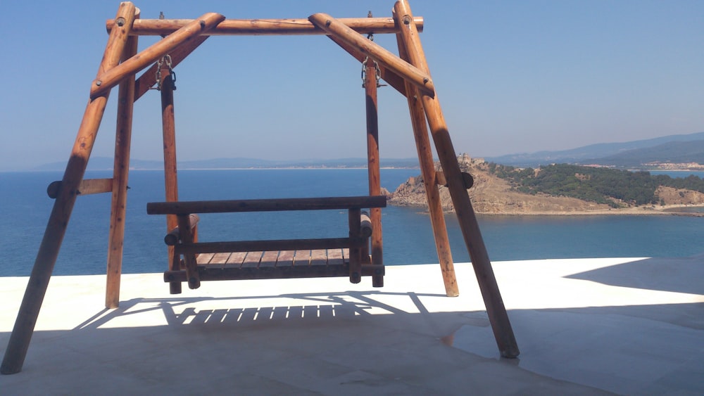 brown wooden swing and body of water during daytime