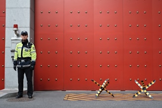 man in yellow top beside red door