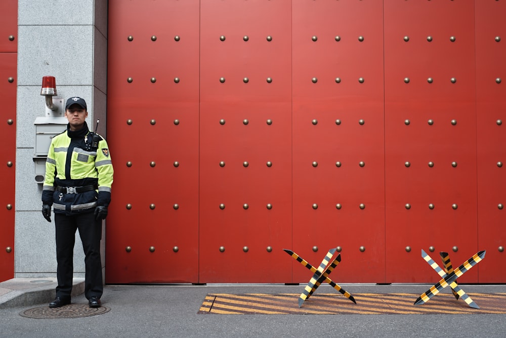 man in yellow top beside red door