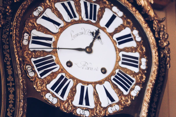 An antique brass clock with delicate engravings and a softly glowing face.